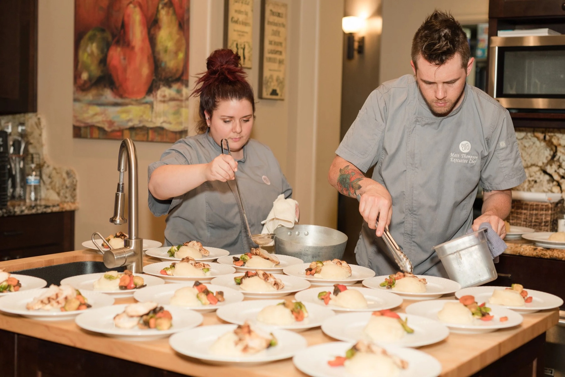 Two Nook cooks plating dishes in the kitchen